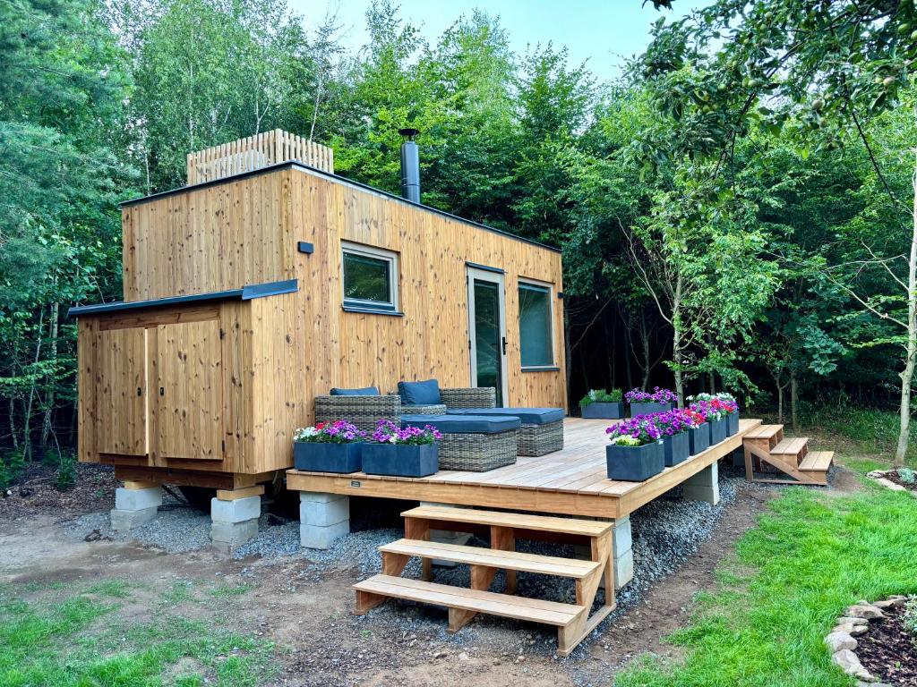 a tiny house sitting on a wooden deck at Maringotka Na mezi in Maršovice