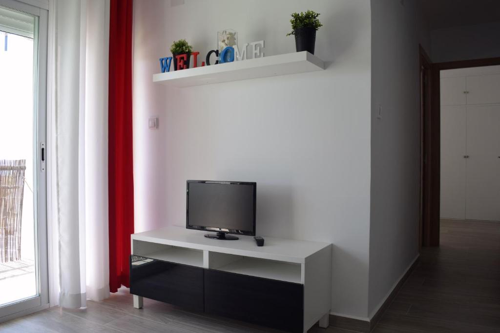 Televízia a/alebo spoločenská miestnosť v ubytovaní Apartamento Flamingo Beach