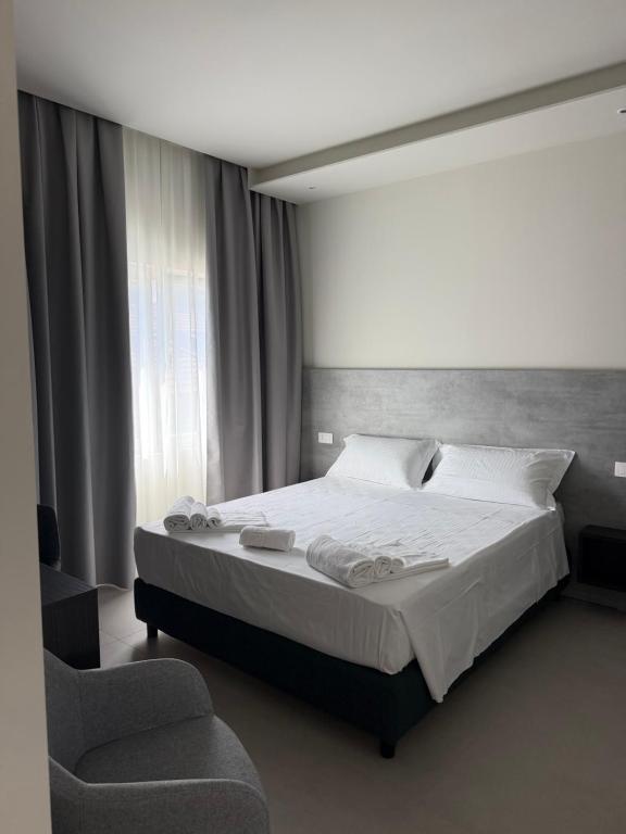 a bedroom with a large bed and a chair at Rooms Residence Rubiera in Rubiera