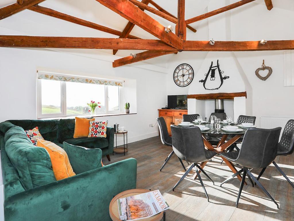 a living room with a green couch and a table at Shippon - Ukc9529 in Barnstaple