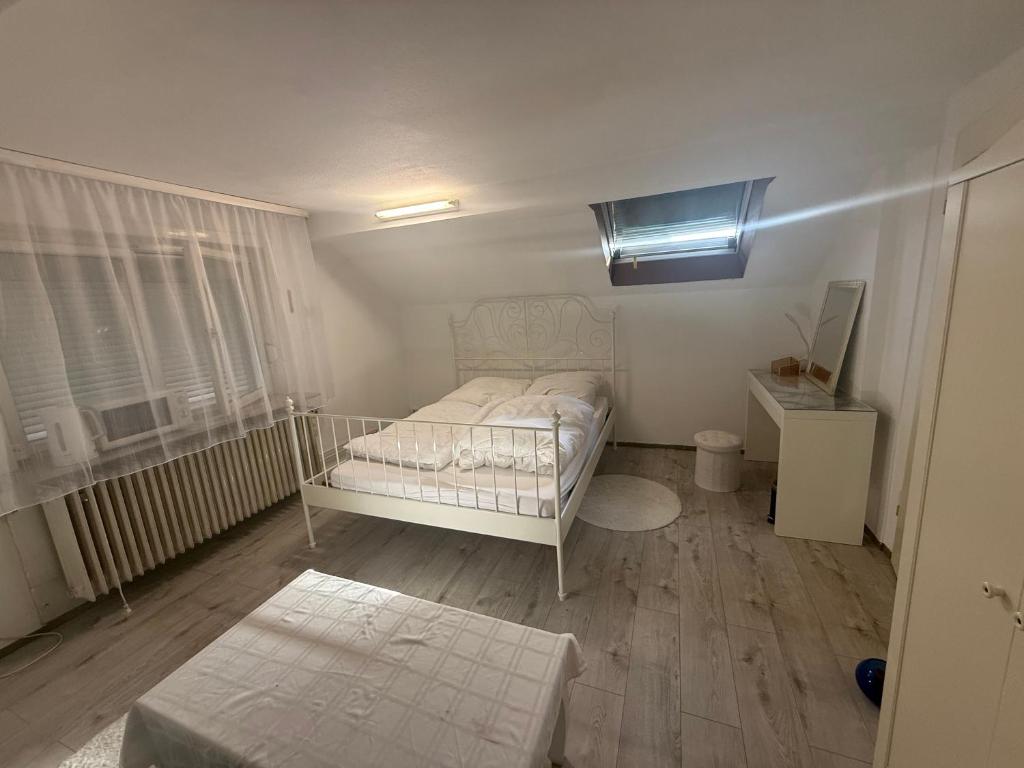 a bedroom with a white bed and a window at Private Top Floor Apartment near Sana Klinik in Offenbach