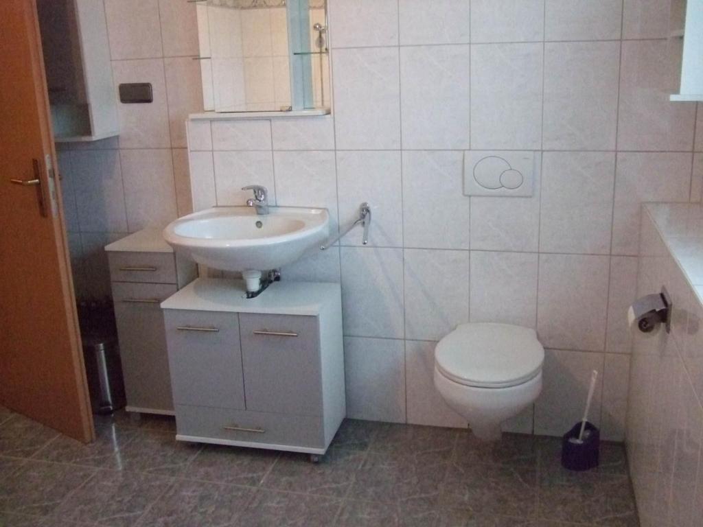 uma casa de banho com um lavatório e um WC em Apartment OG 2 em Peine