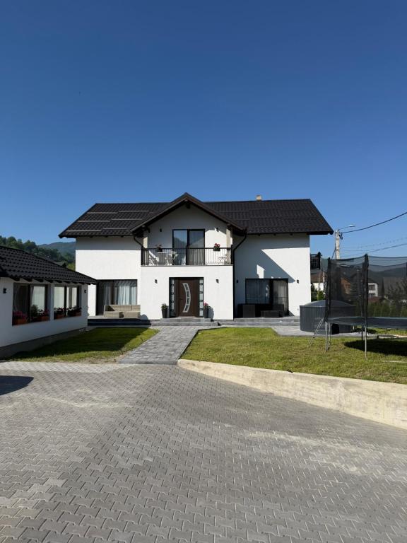 a white house with a driveway in front of it at Casa Lye in Vişeu de Sus