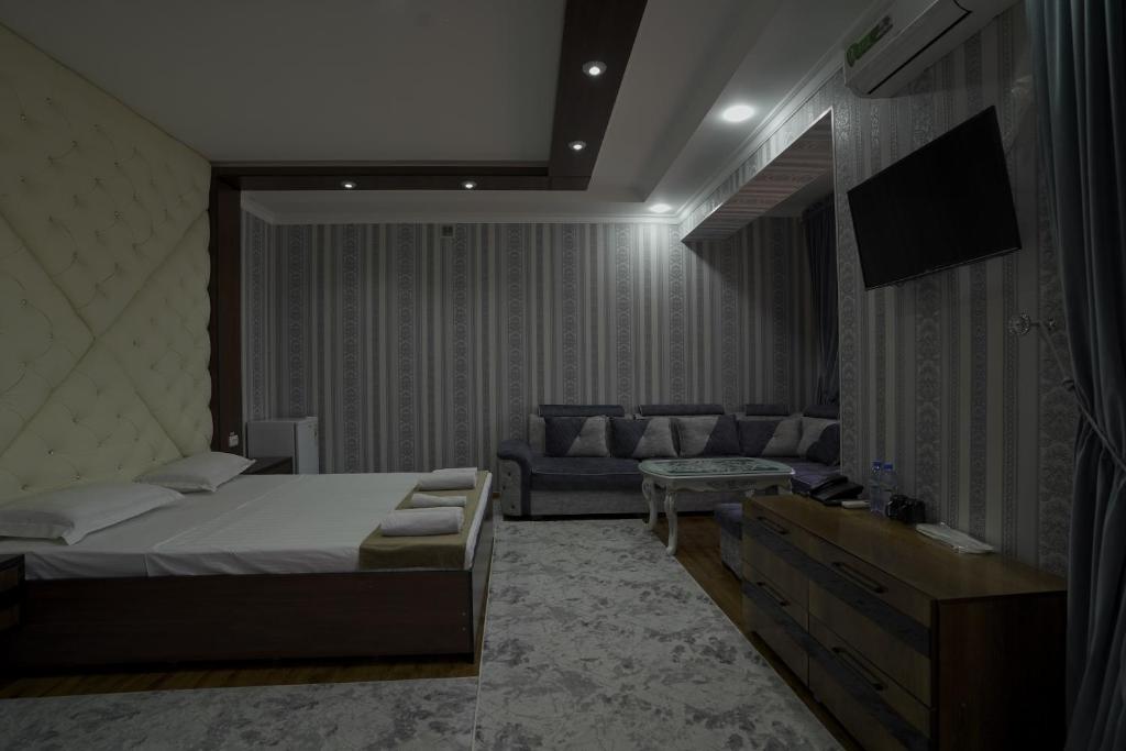 a bedroom with a bed and a couch at Hotel Ayyub Sultan in Urganch