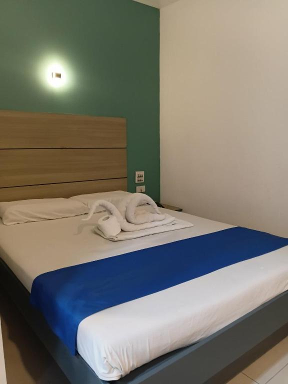 a bed with a blue and white blanket on it at Nice Hotel Recto in Manila