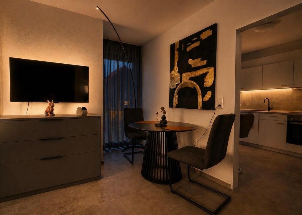 a living room with a table and a tv and a kitchen at TheKarlchen in Rheda-Wiedenbrück