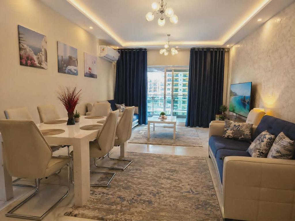 a living room with a table and a dining room at ابراج الداون تاون العلمين الجديده Luxury Apartment In Downtown New Alamein in Ad Darāzīyah