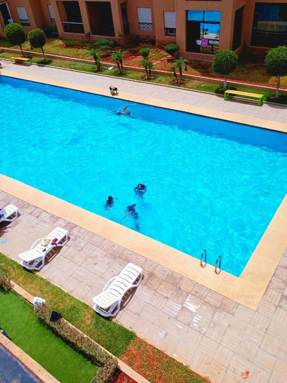 an overhead view of a swimming pool with lounge chairs at Reco flores PALM in Ben Slimane