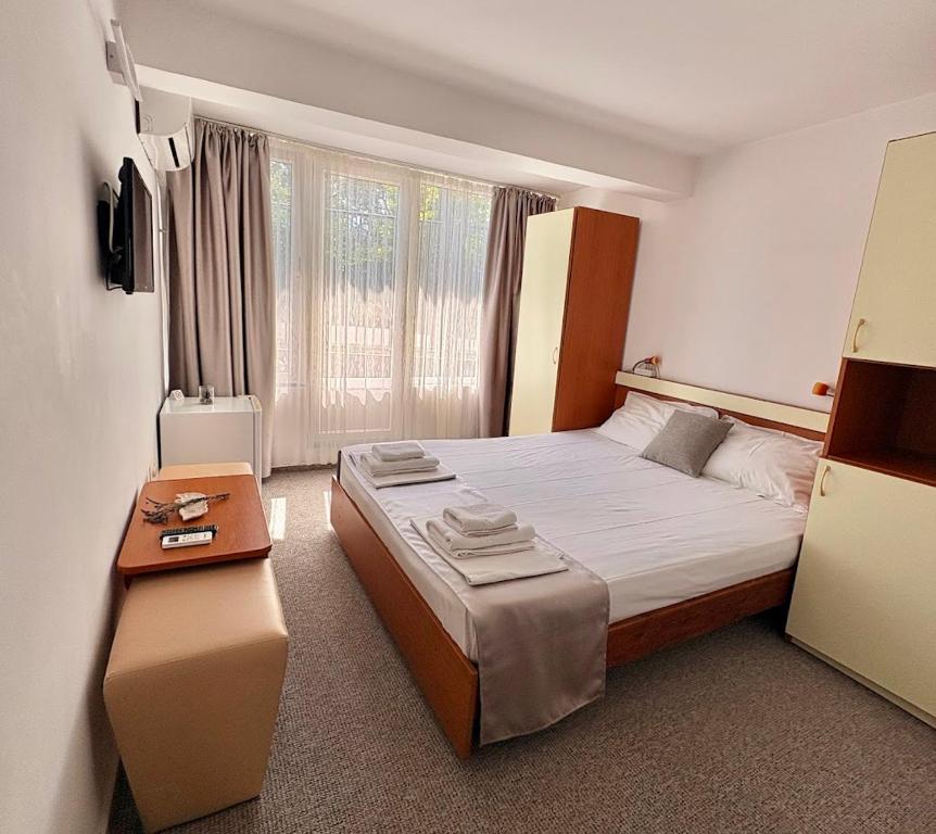 a bedroom with a large bed and a table at Vila Aqua in Eforie Sud