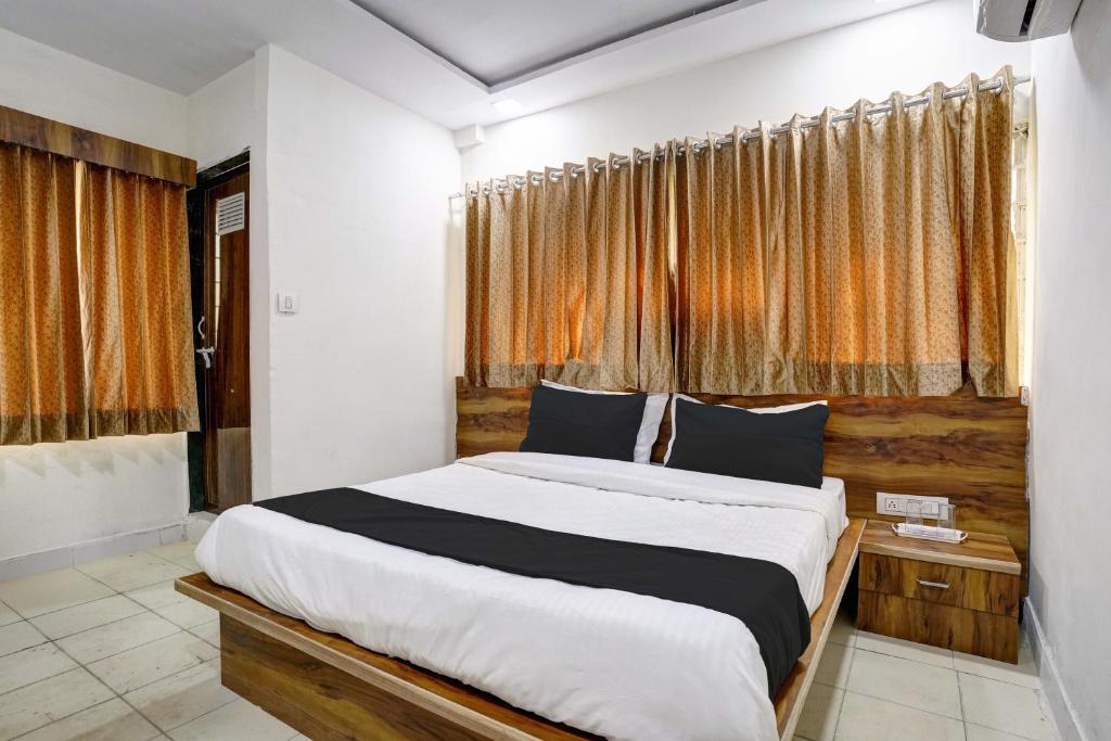 a bedroom with a large bed in front of a window at Hotel O Apollo in Bodakdev