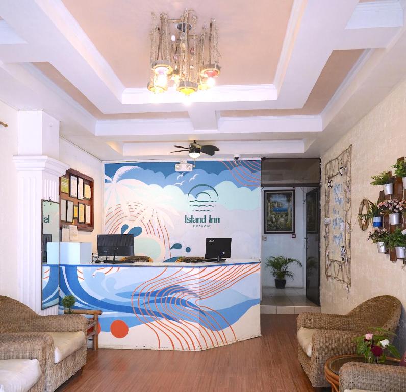 a lobby with a reception desk with a large mural at Island Inn in Boracay