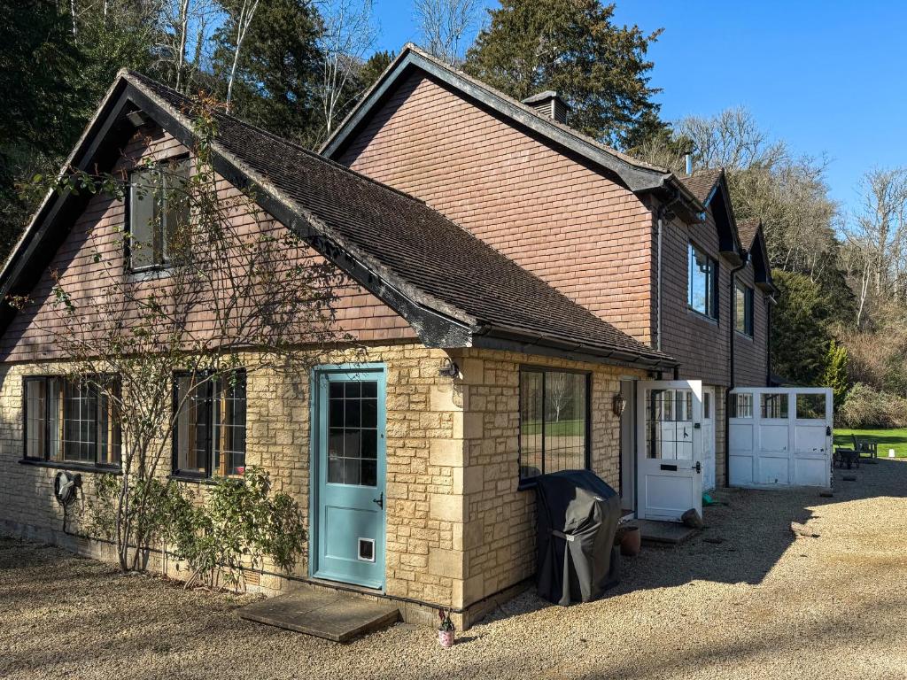 a small brick house with a blue door at Stokewood Annexe in Freshford