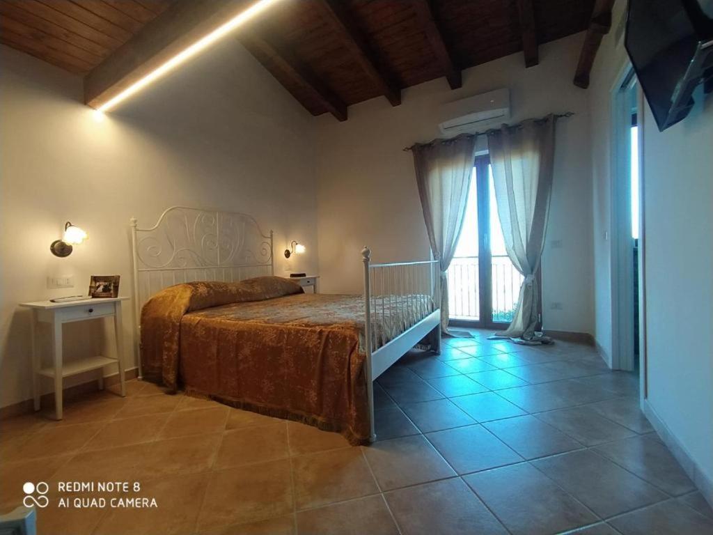 a bedroom with a bed and a large window at La Scienza Nuova in Vatolla