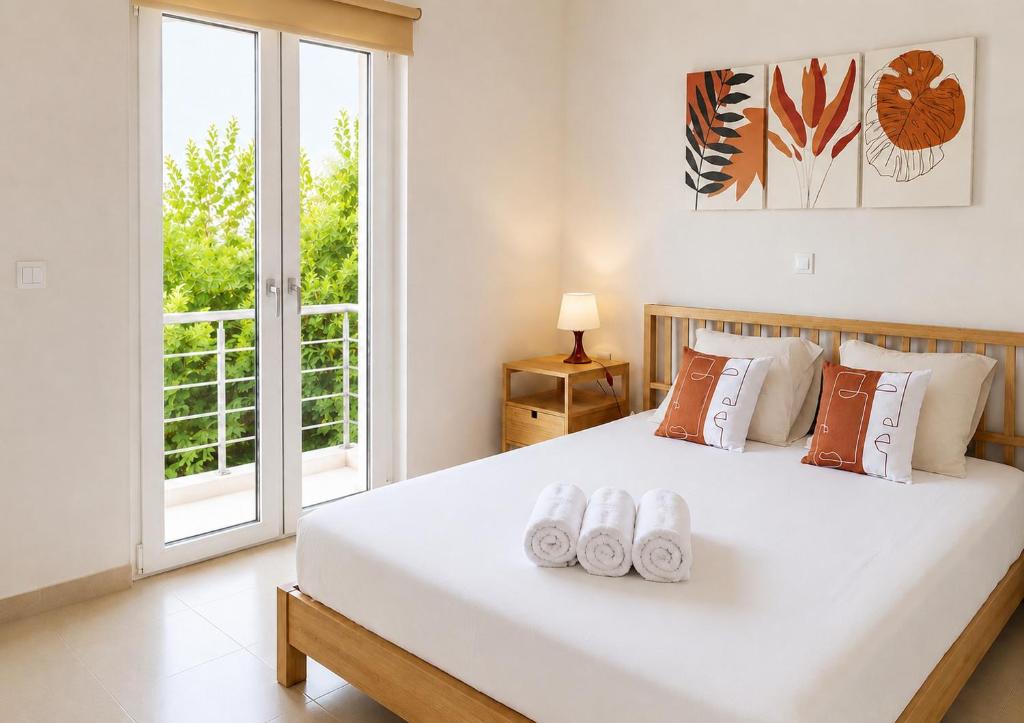 a bedroom with a large white bed and a window at Ionian Studio in Lixouri