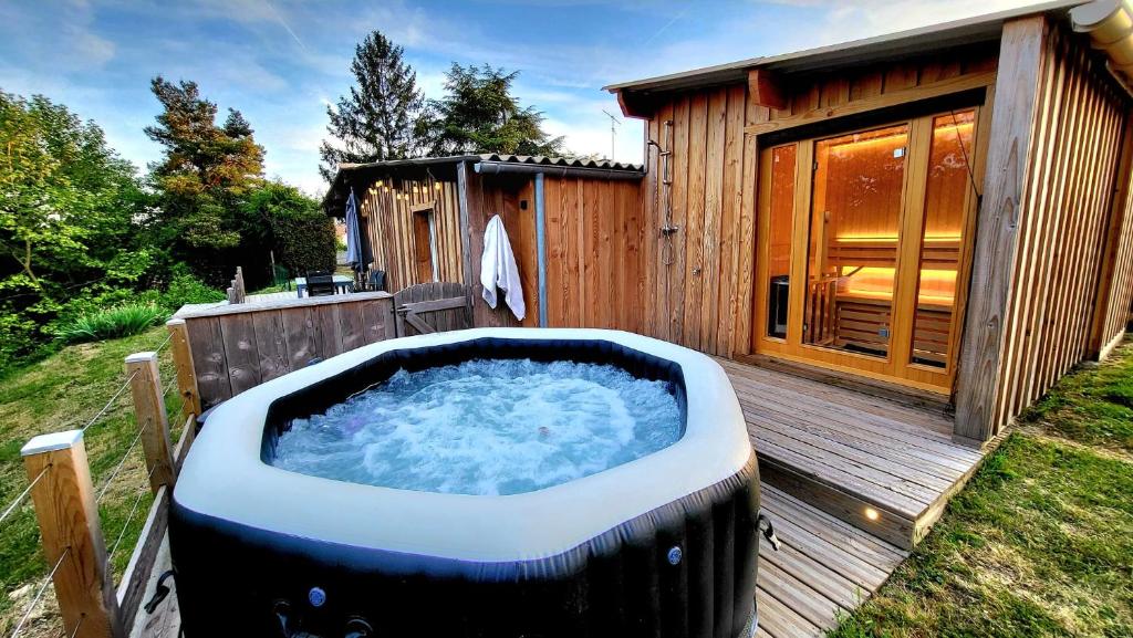 a hot tub sitting on a deck next to a cabin at Loveroom in Lavoux