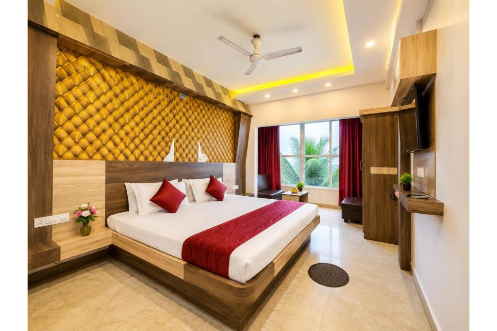 a hotel room with a bed and a television at Hotel Sairaj inn - Restaurant - Free Wi-Fi - Premium Rooms - Balcony - Parking in Puri