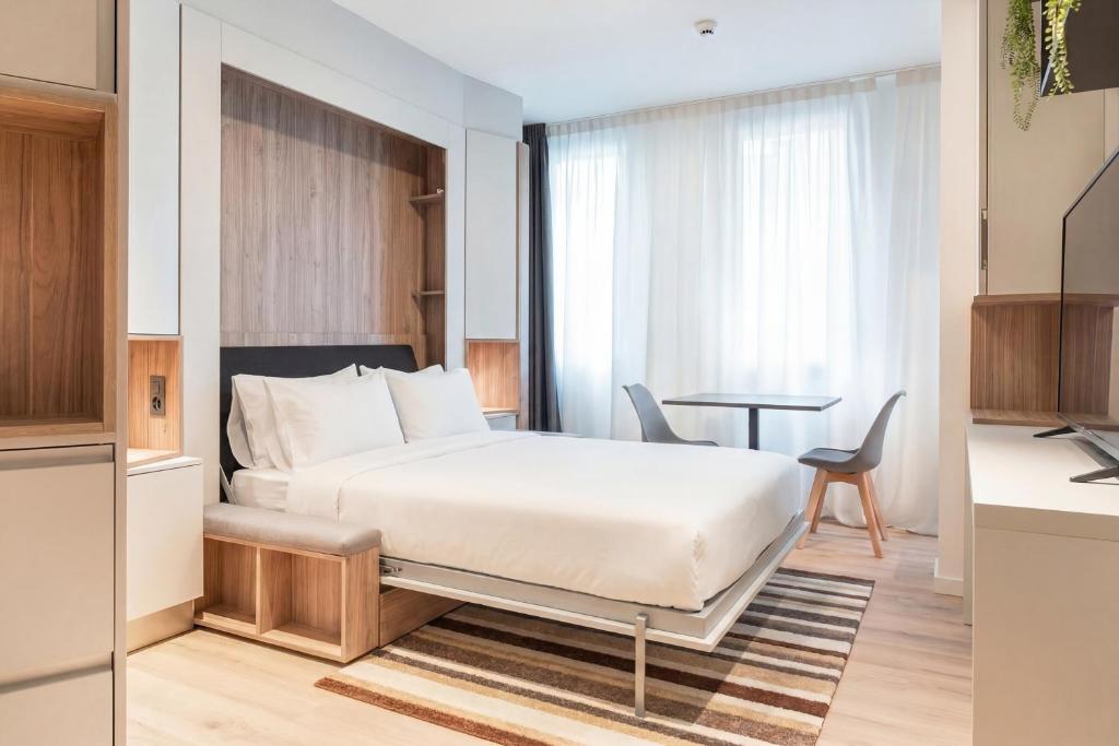 a hotel room with a bed and a table at City Pop 2Night Geneva - Self check-in in Geneva