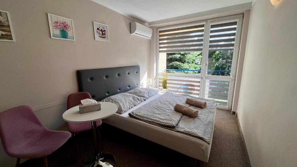 a small bedroom with a bed with a table and a window at NASZE BIAŁE pokój 2 osobowy in Okuninka
