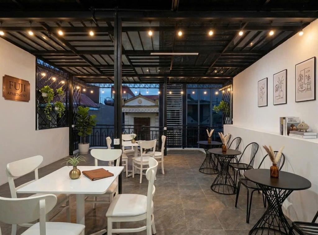 a restaurant with tables and chairs in a room at Fuji Apartment in Hanoi