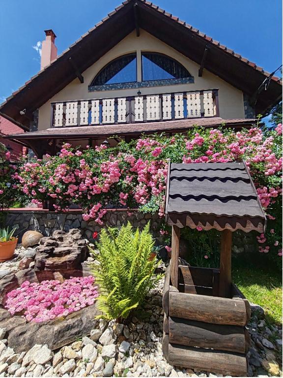 a house with pink flowers in front of it at Casa Veveritelor in Bran