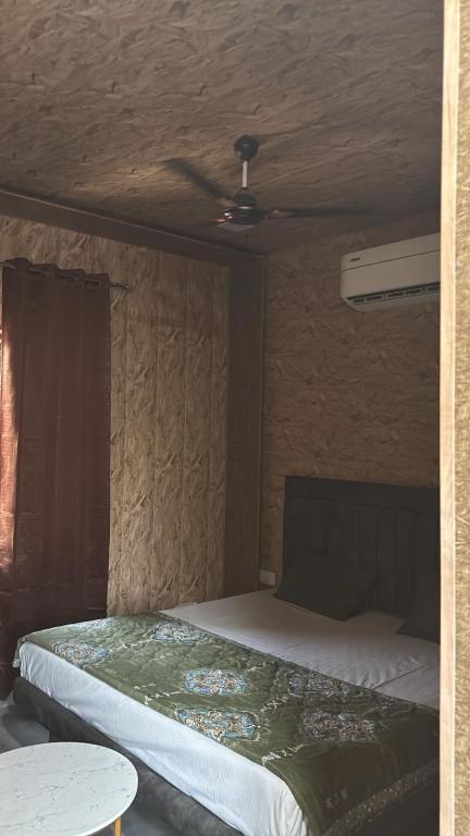 a bedroom with a bed with a ceiling fan at Hotel Dhamija Divine inn Sirsa in Sirsa