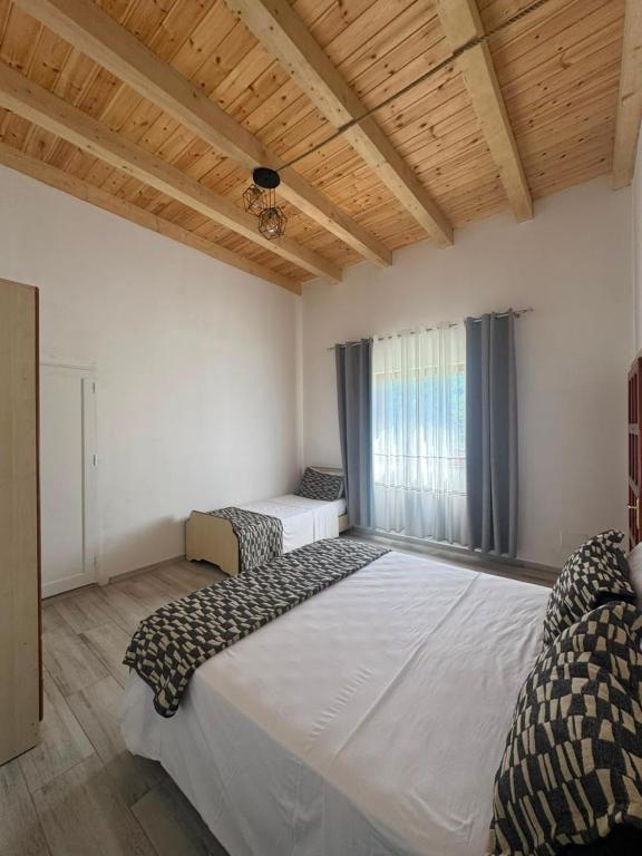 a bedroom with two beds in a room with wooden ceilings at Guesthouse Bjeshket E Arta in Lëpushë