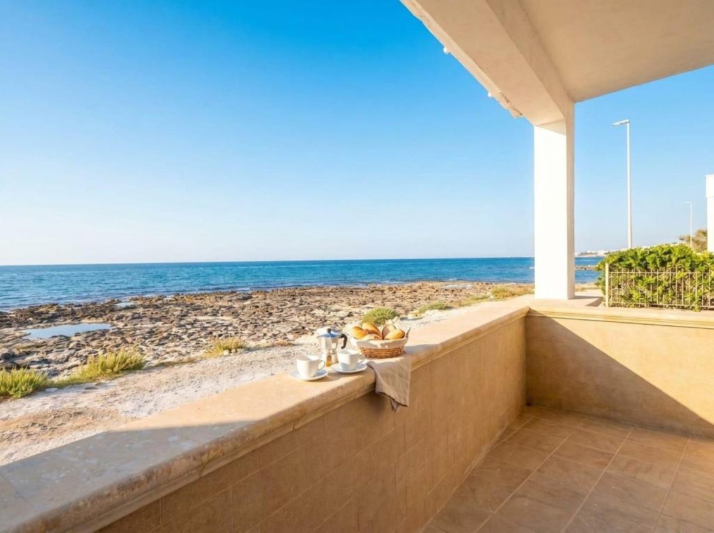 a view of the beach from the balcony of a beach house at SanVitoStea Seafront Apartments in San Vito