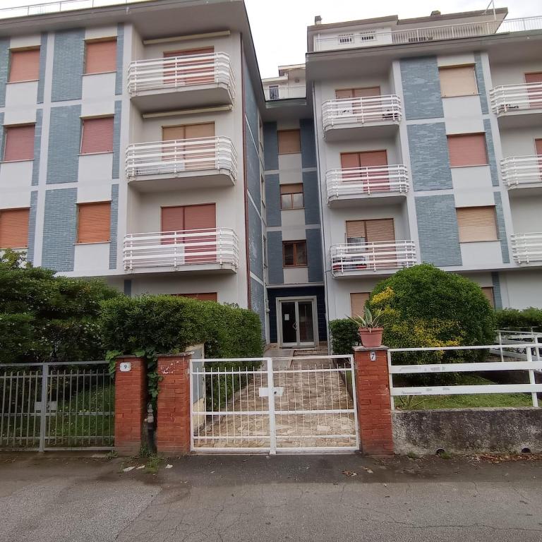 an apartment building with a gate in front of it at Sea Horse in Lido di Camaiore