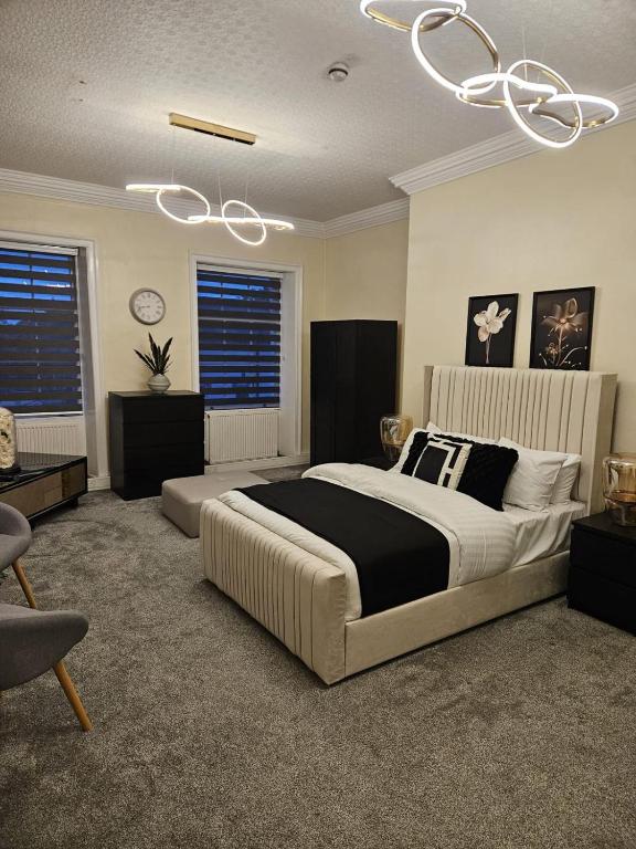 a bedroom with a large bed and a chandelier at Wakefield Town House Accomodation in Wakefield