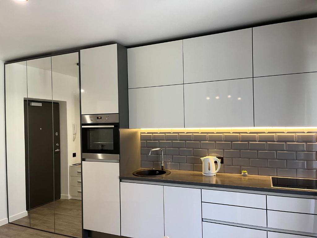 a kitchen with white cabinets and a sink at Near Ozas Studio in Vilnius
