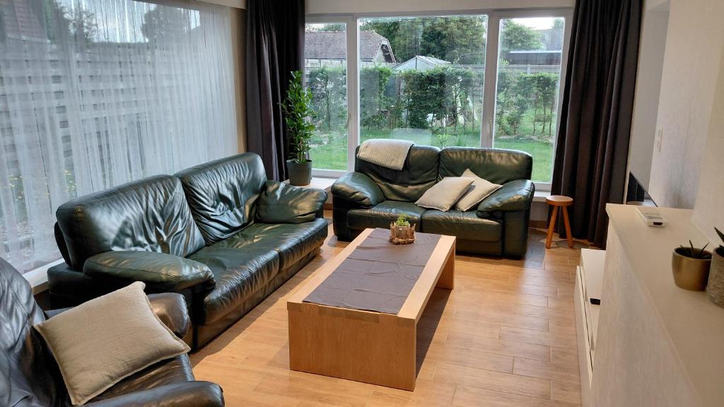 a living room with leather couches and a coffee table at B-SIDE Loppem in Zedelgem