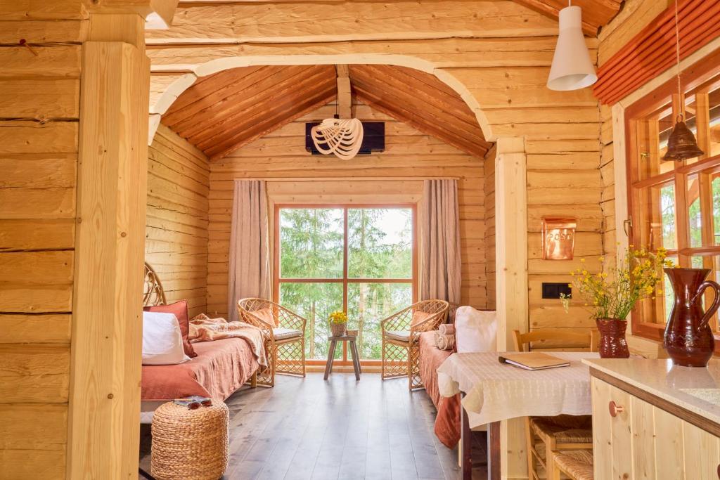 a log cabin living room with a large window at Forest Cabin Ainola with Lake View next to Nuuksio National Park in Otalampi
