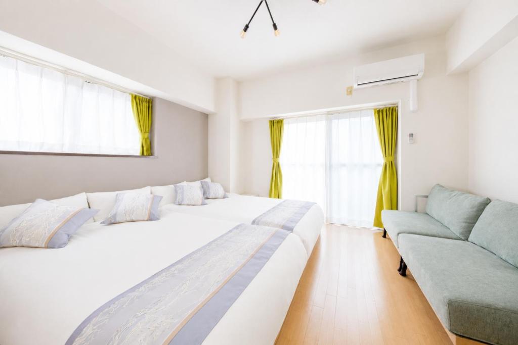 a bedroom with two beds and a couch at 宇都宮ハウスリリー in Utsunomiya