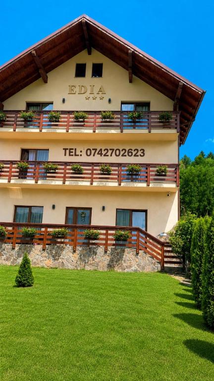 a building with a sign on the side of it at Pensiunea Edia in Borşa