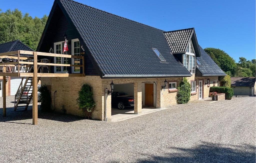 a house with a car parked in a driveway at Penthouse in Hobro