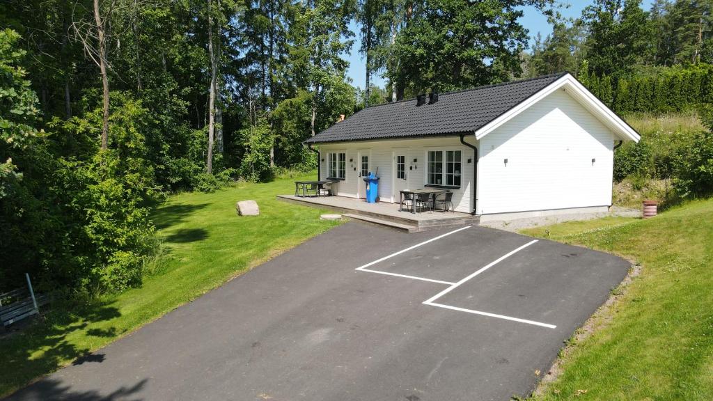 a parking lot in front of a white garage at Villa sjöviken 24 in Kolmården
