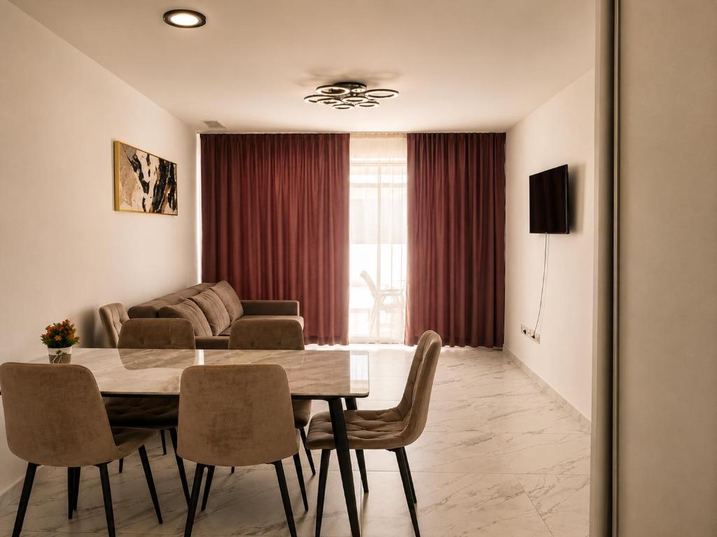 a living room with a table and chairs and a couch at Luxury Beachfront Family Apartment in La Pineda
