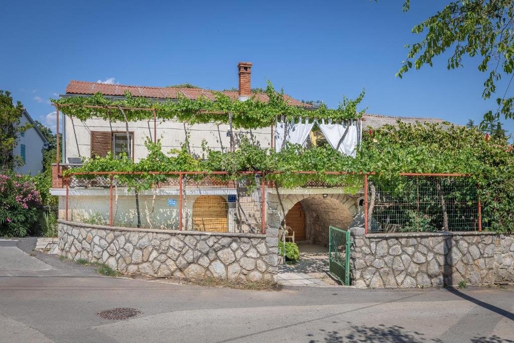 an old stone building with ivy growing on it at Apartment Dinka in Kornić