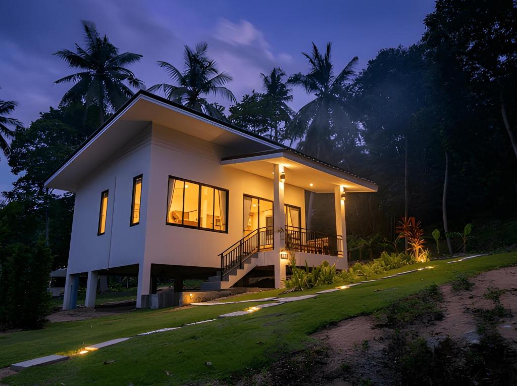 a house with a lit up facade at night at Thara Bohemia Villa in Hinkong
