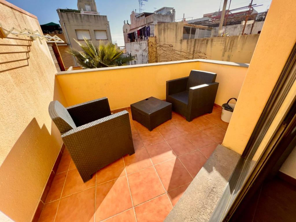 a balcony with two chairs and a table at Perita Apartamentos in Mataró