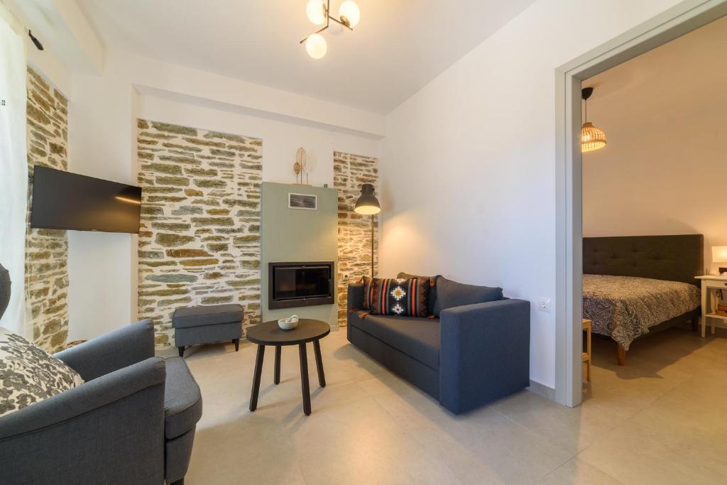a living room with a couch and a table and a bed at Orange House - Lower West appartment in Promírion