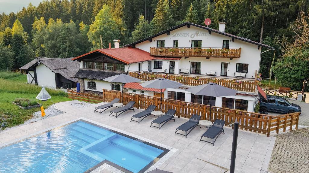 a house with a swimming pool in front of a house at Hotel Sonnenalm Stuhleck in Spital am Semmering