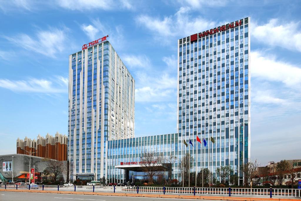東営にあるWanda Realm Hotel Dongyingの都内に二つの塔がある高い建物