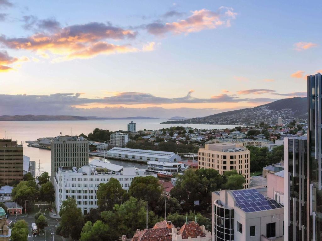 a cityscape of a city with a sunset at Mövenpick Hotel Hobart in Hobart