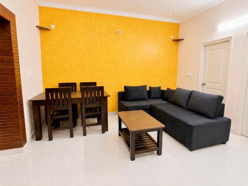a living room with a couch and a table at SV Serviced Apartments in Chikmagalūr