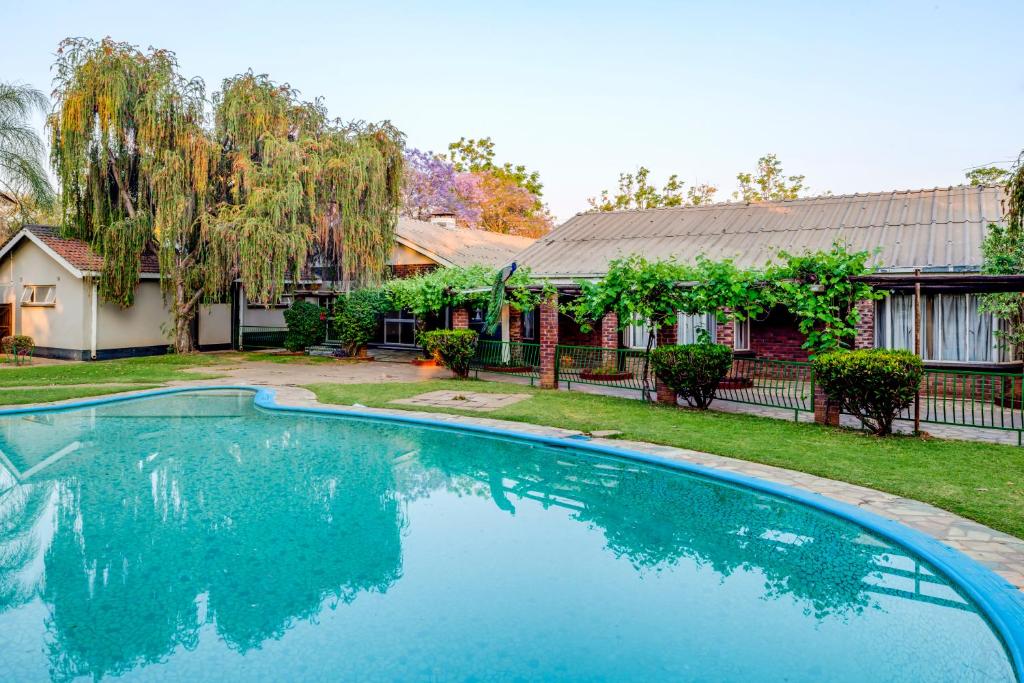 a swimming pool in front of a house at Kadoma Hotel & Conference Centre in Kadoma