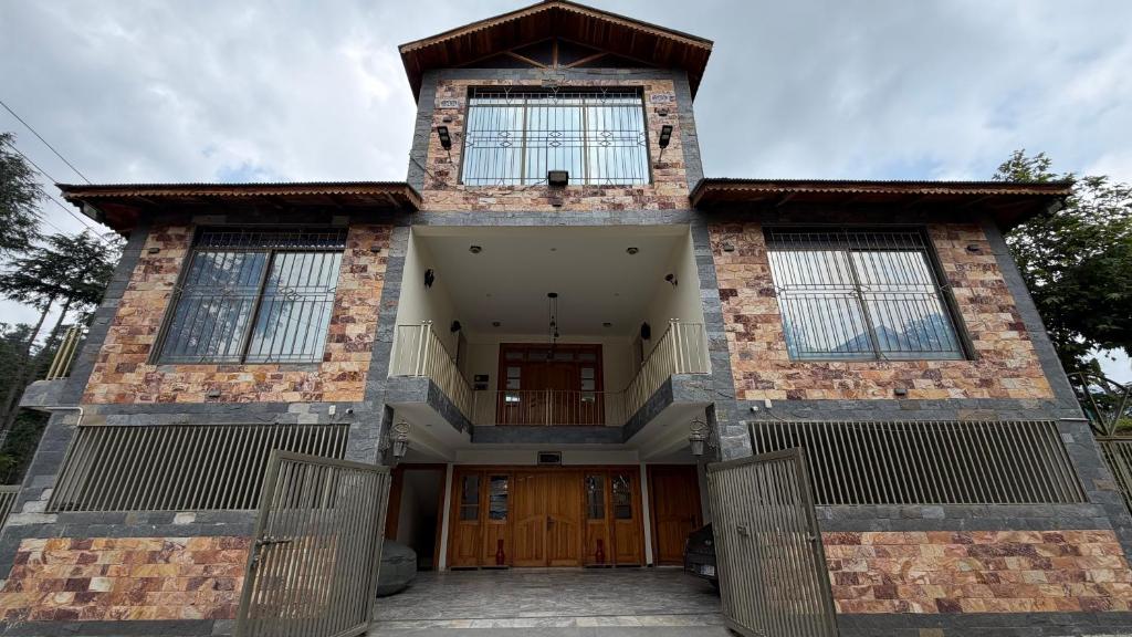 a large brick house with a door and windows at Cascade garden villa in Ayubia