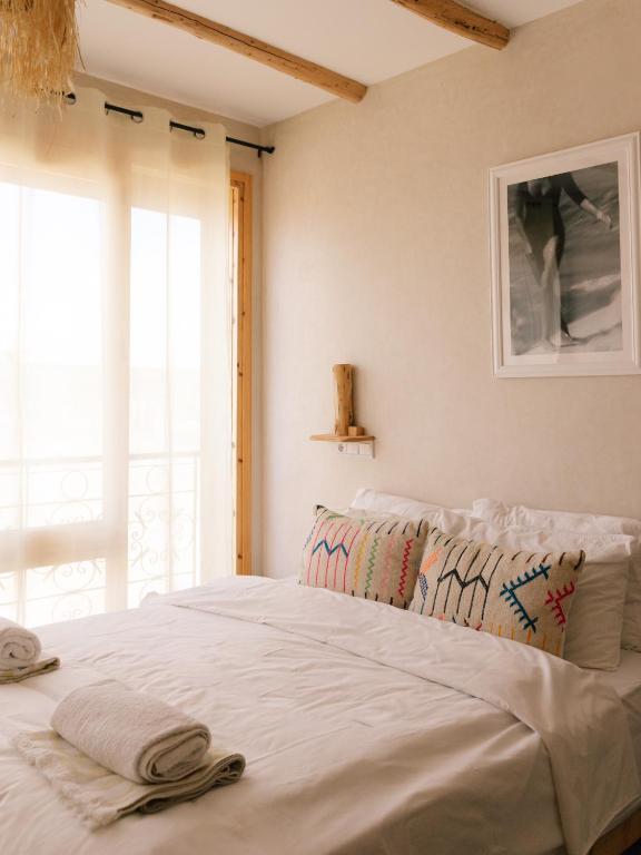 a bedroom with a bed with two towels on it at The Lodge - Boutique Hotel and Creative Residency in Tamraght Ouzdar