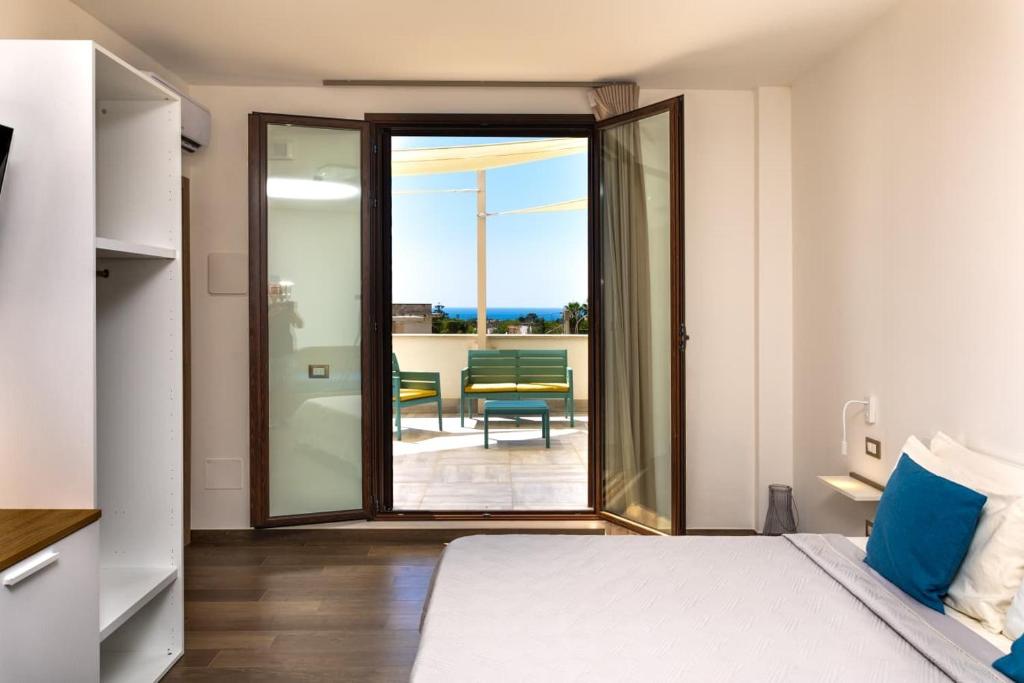 a bedroom with a bed and a view of a patio at kalispera in Cinisi