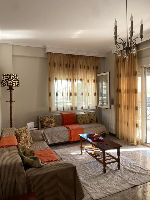 a living room with a couch and a table at Watermelon Home in Nea Moudania